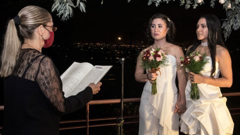 Alexandra Quiros (center) and Dunia Araya (right) stand before a lawyer during their wedding in Heredia.
