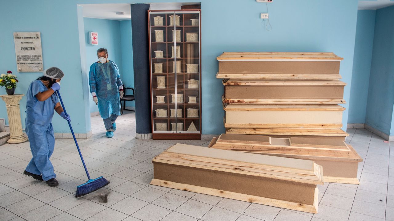 A worker sweeps the floor next to coffins for Covid-19 victims at El Angel cemetery, in Peru's capital, Lima, on May 21.