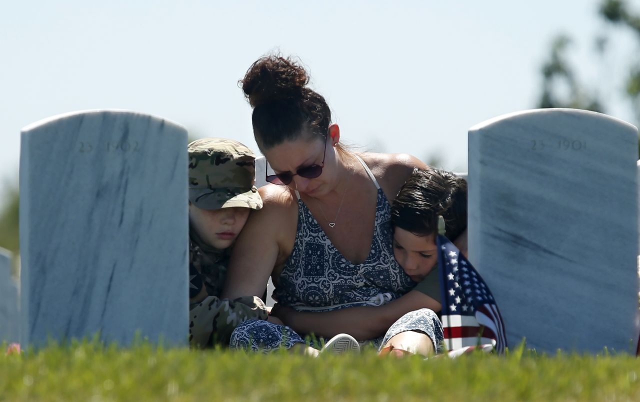 Heidi Hannah hugs her sons Tomas, left, and Lucas while visiting the grave of her oldest son, Army Spec. Taylor Hannah, at the Sacramento Valley National Cemetery in Dixon, California, on Monday. Taylor Hannah, 22, died on March 1 of a rare blood disease.