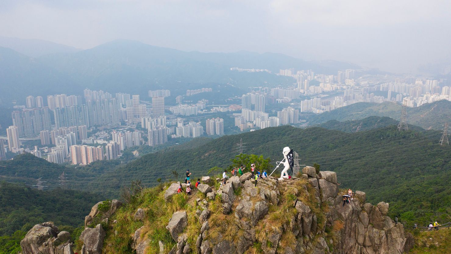 This aerial photo shows a four-metre statue known as "Lady Liberty" (C), after it was hauled by pro-democracy protesters to the top of Lion Rock, one of the Hong Kong's most famous mountain tops, on October 13, 2019, announcing that the peak would be its "final resting" place. - The statue depicts a female protester in a gas mask, protective goggles and helmet, an umbrella in one hand and a black flag in the other, proclaiming the protest slogan "Liberate Hong Kong, revolution of our times". (Photo by Anthony WALLACE / AFP) (Photo by ANTHONY WALLACE/AFP via Getty Images)