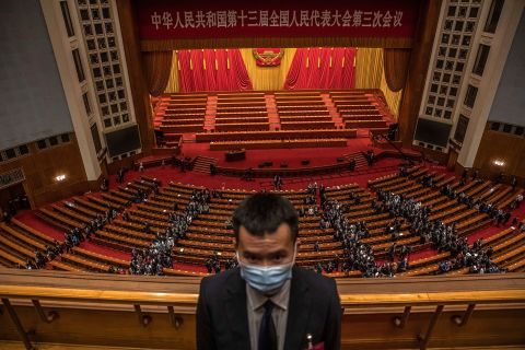 A security official stands guard at the Great Hall of the People in Beijing as delegates leave the second plenary session of the National People's Congress.