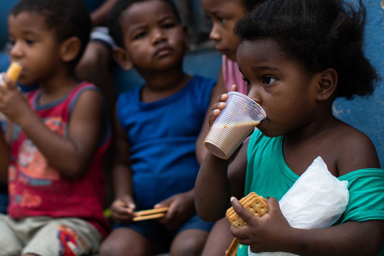 Children eat breakfast during a food distribution in Rio de Janeiro on May 24.