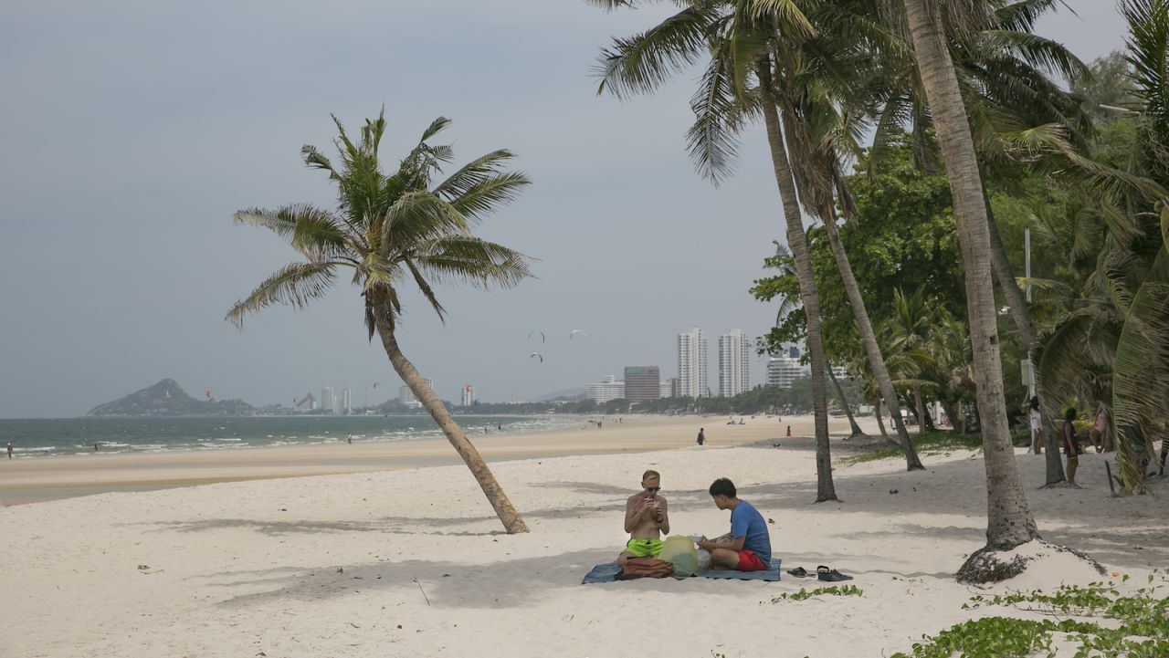<strong>Hua Hin, Thailand: </strong>People sit on the beach on May 24, 2020 in Hua Hin, Thailand's oldest beach resort. Provincial officials there signed orders to re-open hotels last week. The resort town is about a 2.5-hour drive from Bangkok, making it a popular weekend destination for locals. 