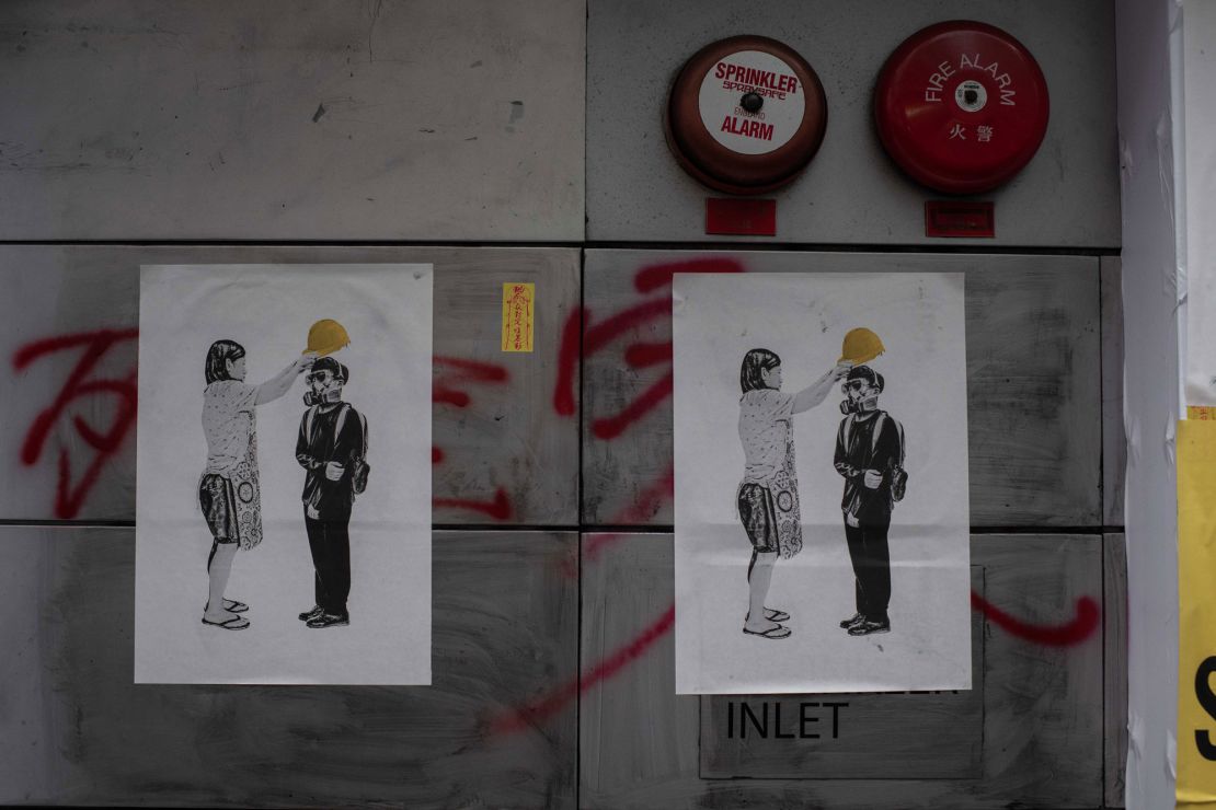 20,000 posters from the "Yellow Objects" exhibition -- such as this one, depicting a mother helping her son wear a helmet for a demonstration -- were distributed to the public, and plastered throughout the city. The photo was taken in the Wan Chai district of Hong Kong on January 1, 2020. 