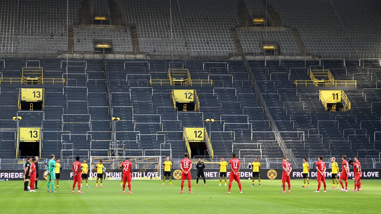 Players observe a minute of silence for the victims of the coronavirus before the German first division Bundesliga soccer match Borussia Dortmund and FC Bayern Munich.