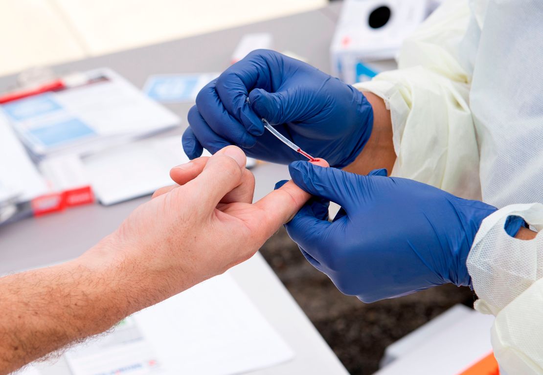 A health worker takes a drop of blood for an antibody test at the Diagnostic and Wellness Center in Torrance, California.