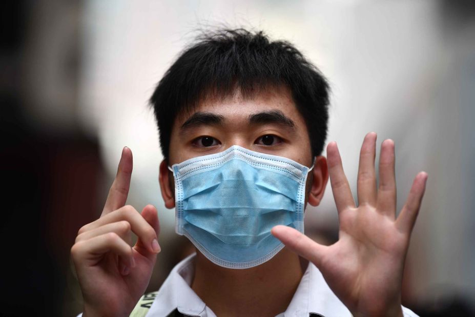 A young man uses the "five demands, not one less" gesture during a protest on May 27.