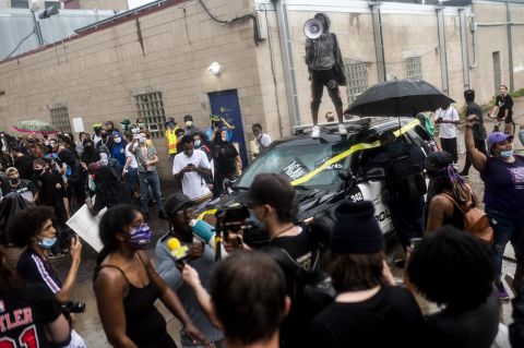 Protesters rally around a damaged police vehicle in Minneapolis on May 26.
