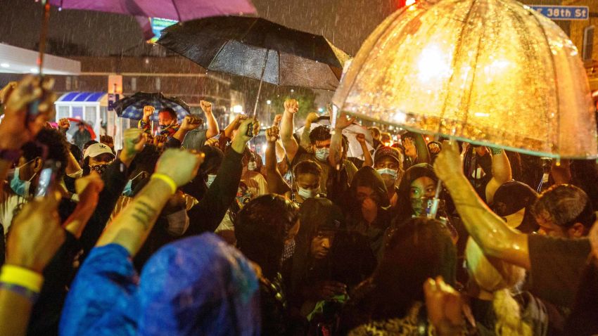 TOPSHOT - Protesters gather under the rain near the spot where George Floyd died while in custody of the Minneapolis Police, on May 26, 2020 in Minneapolis, Minnesota. - A video of a handcuffed black man dying while a Minneapolis officer knelt on his neck for more than five minutes sparked a fresh furor in the US over police treatment of African Americans Tuesday. Minneapolis Mayor Jacob Frey fired four police officers following the death in custody of George Floyd on Monday as the suspect was pressed shirtless onto a Minneapolis street, one officer's knee on his neck. (Photo by Kerem Yucel / AFP) (Photo by KEREM YUCEL/AFP via Getty Images)