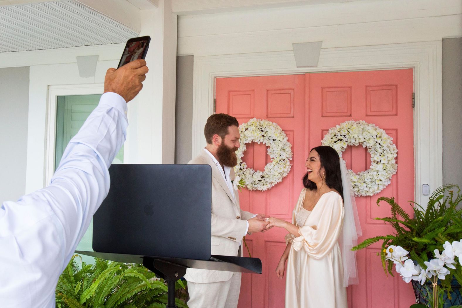 Gary Kafei records part of Philip Rosengreen and Afsy Kafei's wedding ceremony at Afsy's parents' house in Fort Myers, Florida, on May 23. The couple had to cancel their wedding in Spain due to the pandemic.