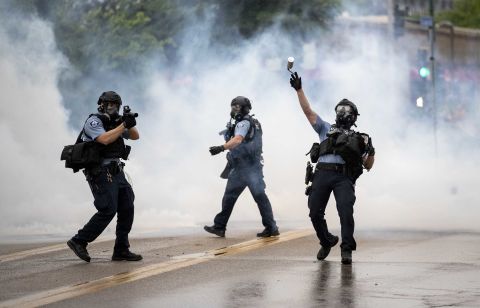 A police officer throws a tear-gas canister toward protesters during a rally in Minneapolis on May 27.