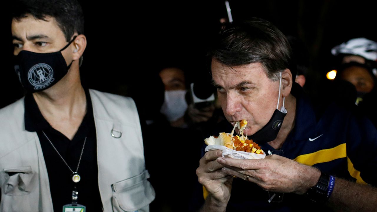 Bolsonaro was met with angry protestors when eating a hotdog in Brasilia.