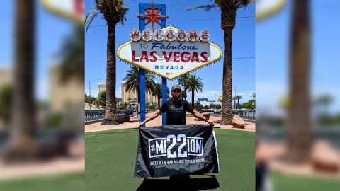 Peter Makredes holds a Mission 22 banner in Las Vegas.