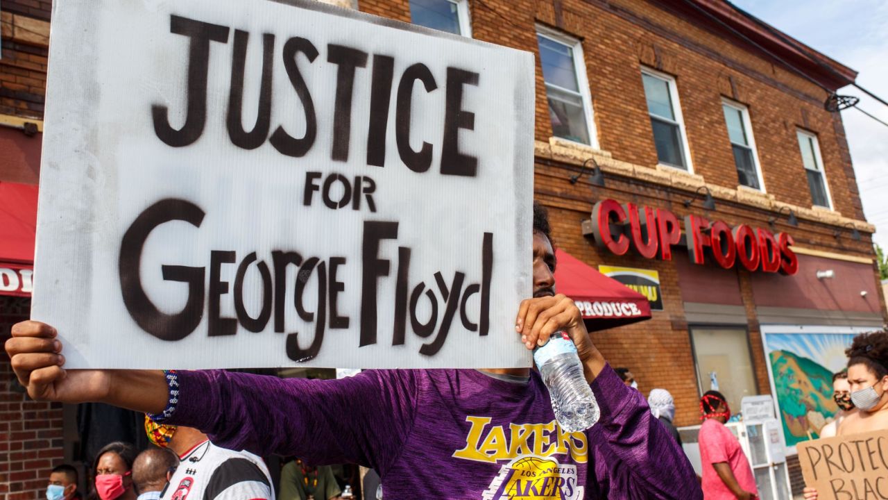 A man holds a sign while protesting near the area where a Minneapolis Police Department officer allegedly killed George Floyd, on May 26, 2020 in Minneapolis, Minnesota. - A video of a handcuffed black man dying while a Minneapolis officer knelt on his neck for more than five minutes sparked a fresh furor in the US over police treatment of African Americans Tuesday. Minneapolis Mayor Jacob Frey fired four police officers following the death in custody of George Floyd on Monday as the suspect was pressed shirtless onto a Minneapolis street, one officer's knee on his neck. (Photo by Kerem Yucel / AFP) (Photo by KEREM YUCEL/AFP via Getty Images)