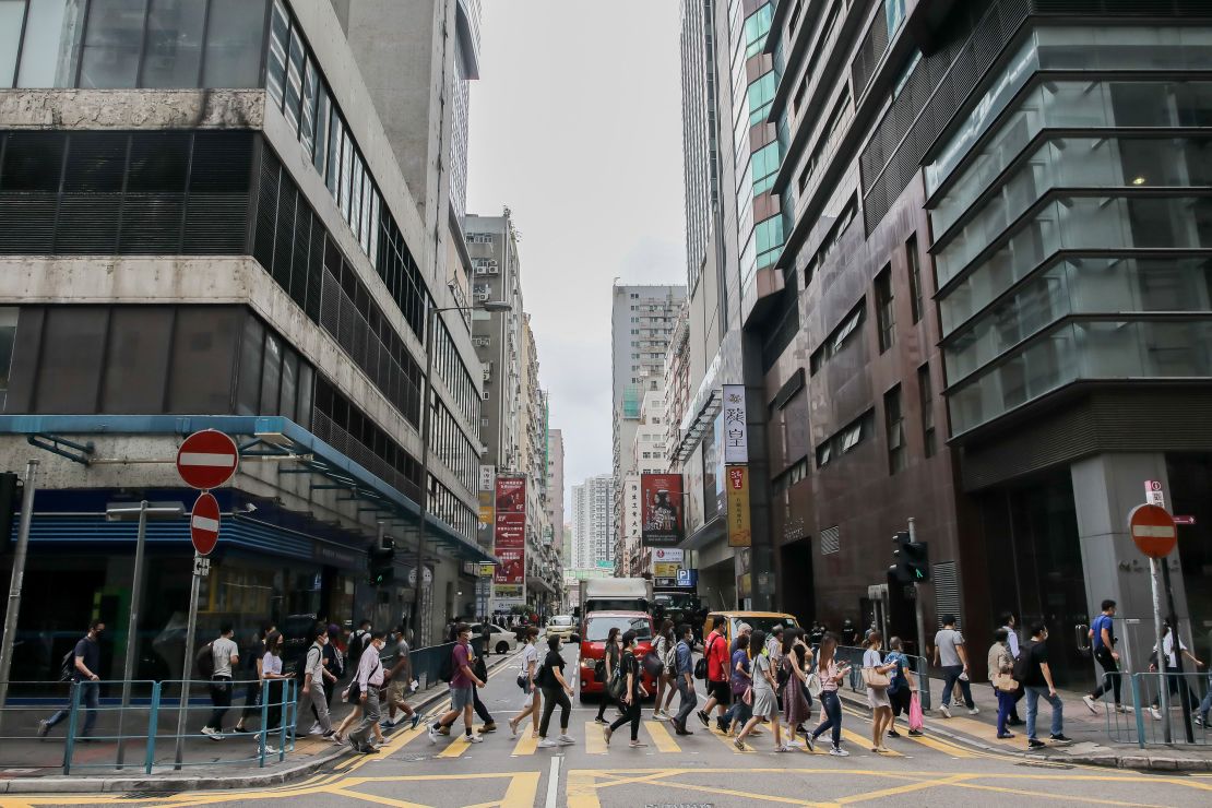 Pedestrians wearing protective masks cross a road during the morning rush hour in the Kwun Tong district of Hong Kong on May 6.