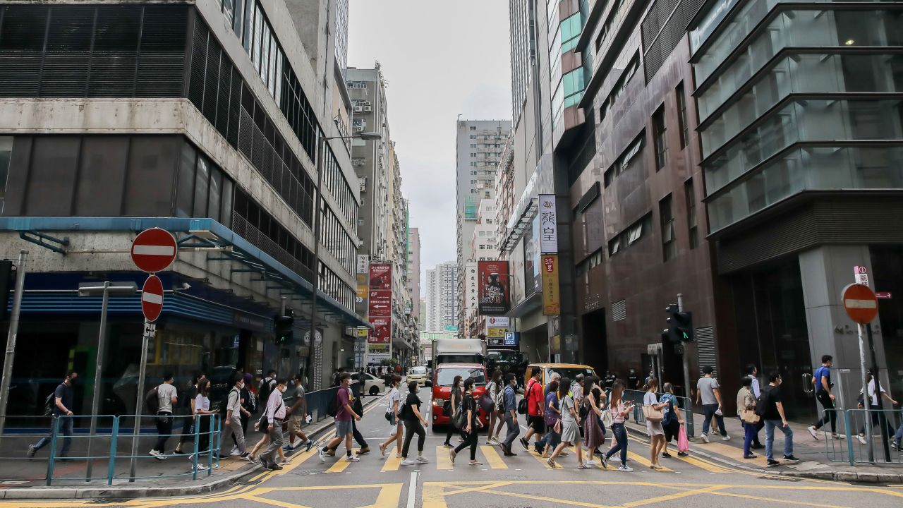 Pedestrians wearing protective masks cross a road during the morning rush hour in the Kwun Tong district of Hong Kong on May 6.