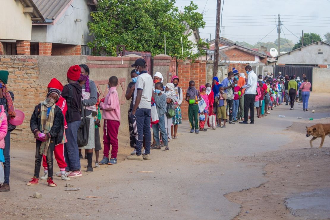 Children queue for food outside Murozoki's kitchen in Zimbabwe. 