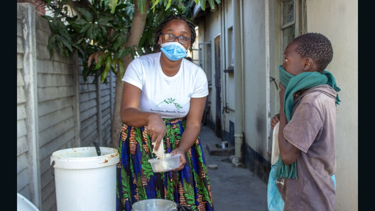 Samantha Murozoki serves food to a young child. 