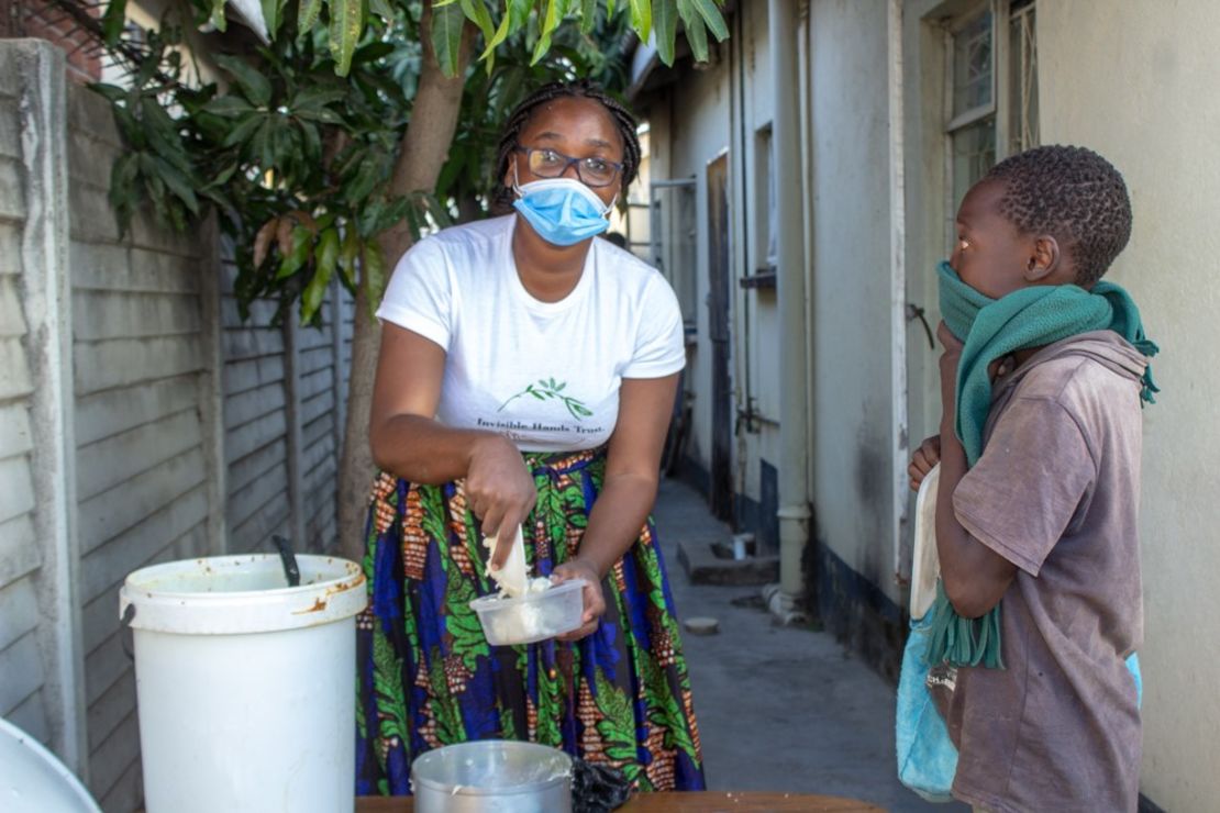 Samantha Murozoki serves food to a young child. 