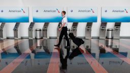 An airline employee walks past empty American Airlines check-in terminals at Ronald Reagan Washington National Airport in Arlington, Virginia, on May 12, 2020. - The airline industry has been hit hard by the COVID-19 pandemic, with the number of people flying having decreased by more than 90 percent since the beginning of March. (Photo by Andrew Caballero-Reynolds/AFP/Getty Images)