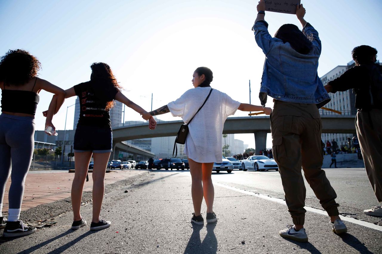 People join hands across a freeway during a protest in Los Angeles on May 27.