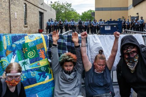 Protesters raise their hands up as they react to tear gas during a demonstration in Minneapolis on May 27.