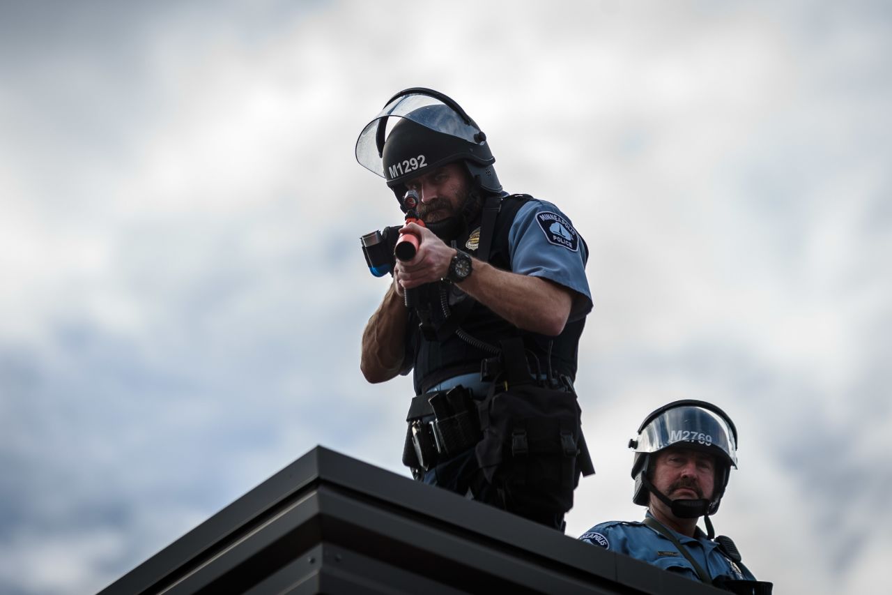 Two police officers stand on the roof of a Minneapolis police precinct during demonstrations on May 27.