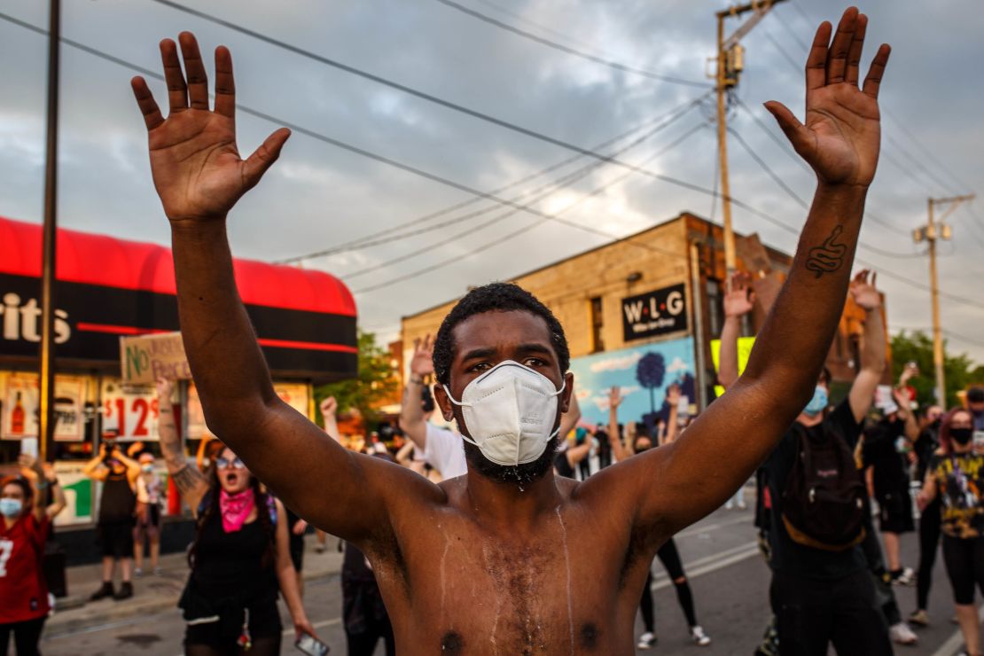 A protester wearing a face mask holds up his hands during a demonstration Wednesday in Minneapolis.
