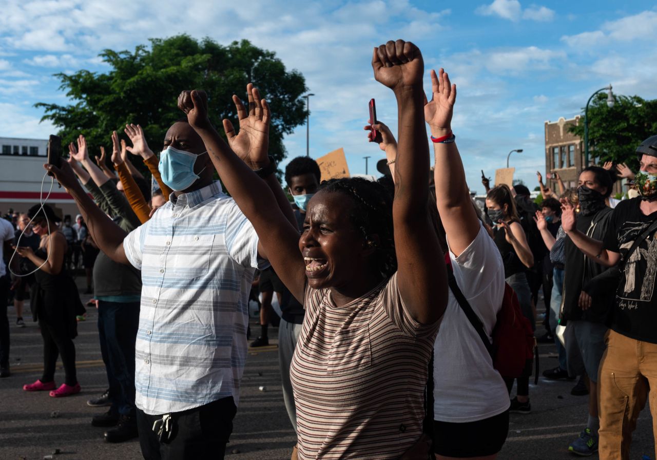 Demonstrators in Minneapolis raise their hands during a standoff with police on May 27.