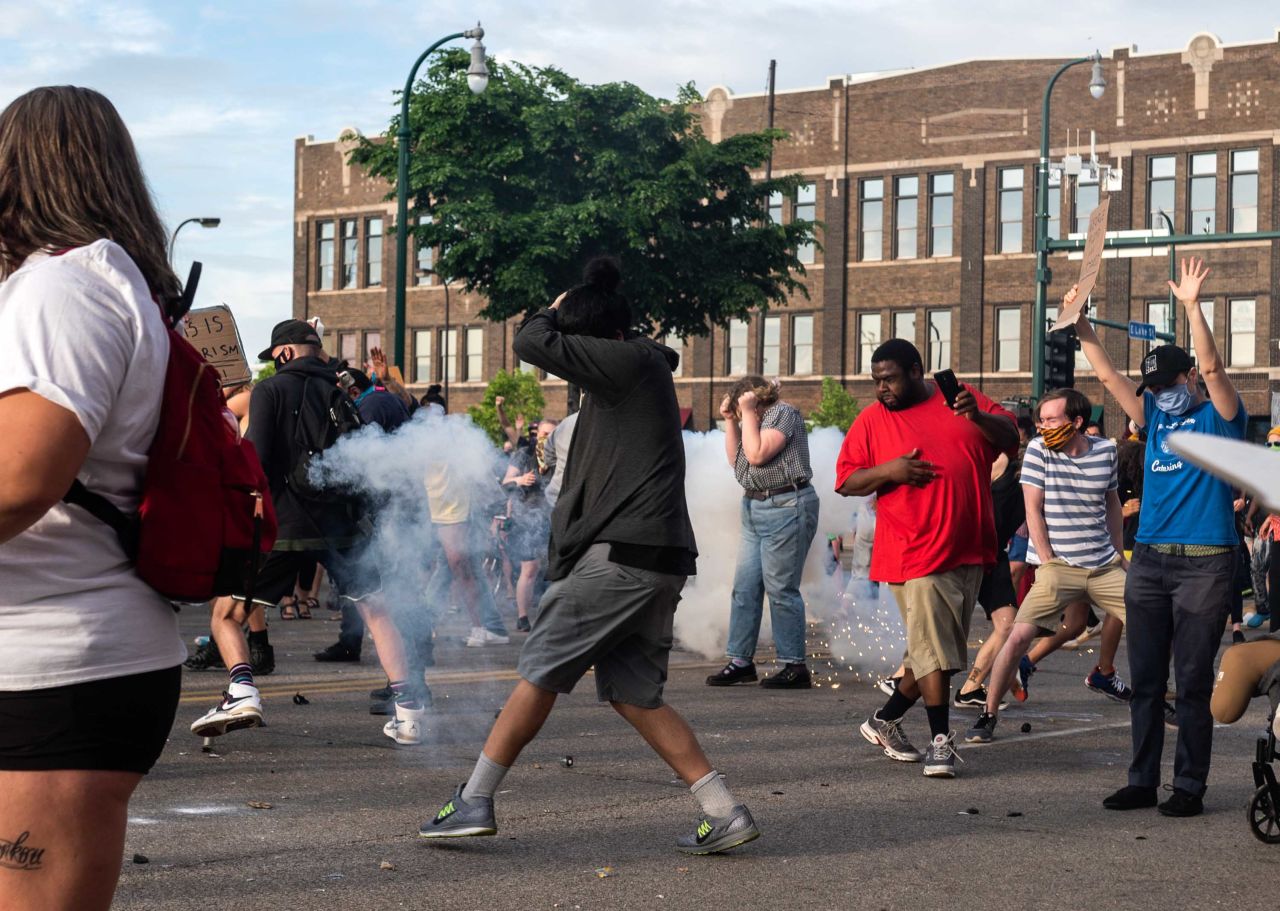 Minneapolis protesters react as a projectile launched by police explodes near them on May 27.