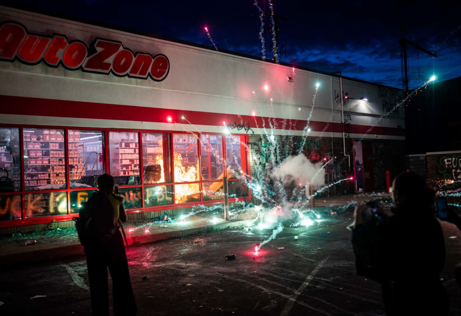 A firework explodes as a fire burns inside an Auto Zone store in Minneapolis on May 27.