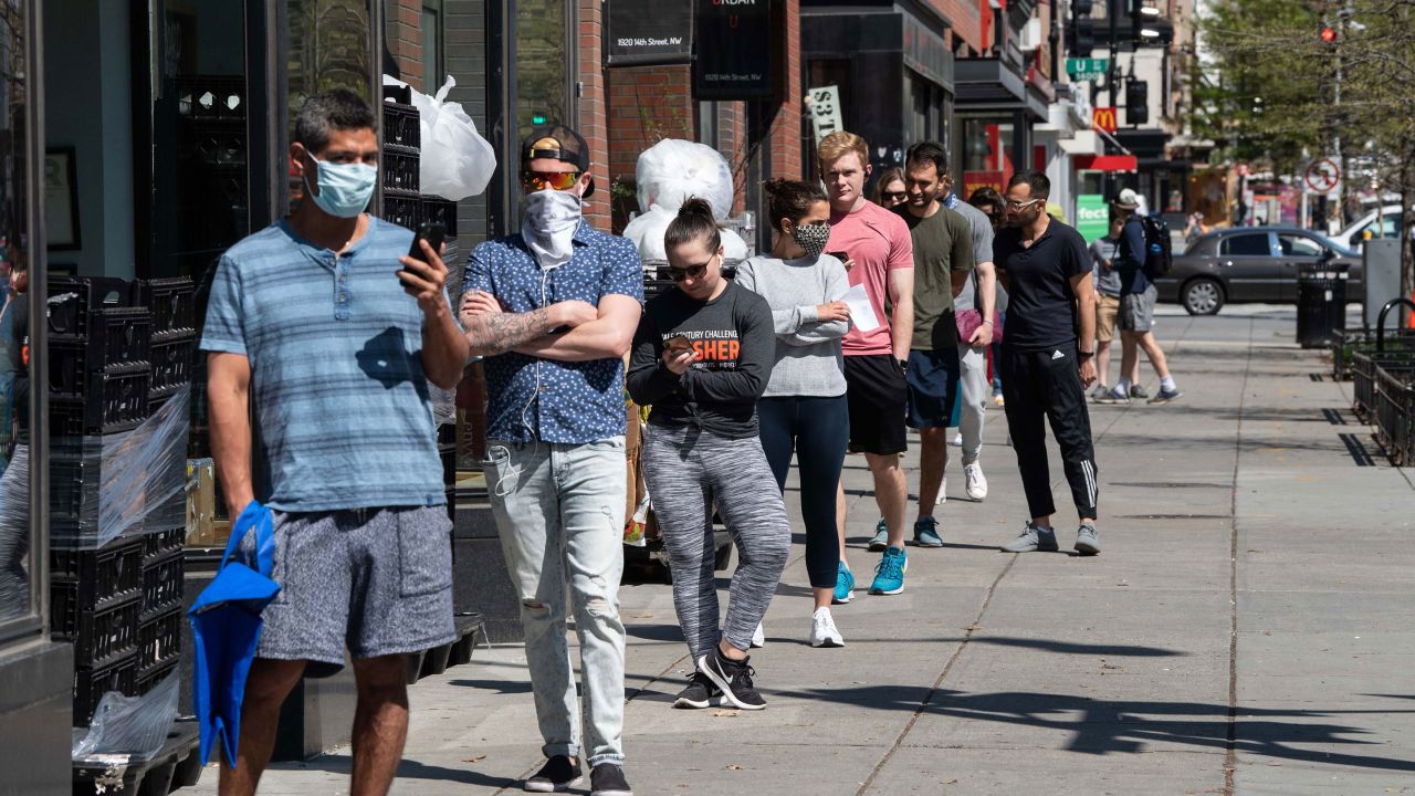 People stand in line to enter a grocery store in Washington, D.C., on April 8.
