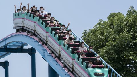 Visitors wearing face masks ride a roller coaster at the Tochinoki Family Land amusement park on May 17, 2020 in Utsunomiya, Tochigi, Japan. 