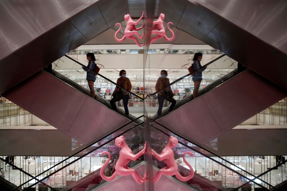 Customers stand on an escalator inside Le Printemps Haussmann, a department store in Paris, on May 28.