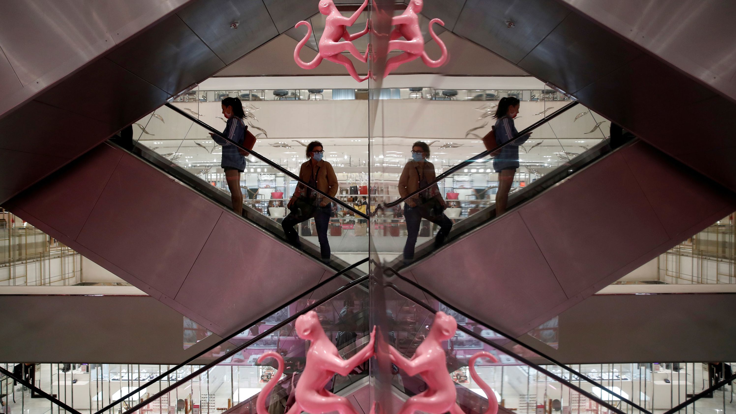 Customers stand on an escalator inside Le Printemps Haussmann, a department store in Paris, on May 28.