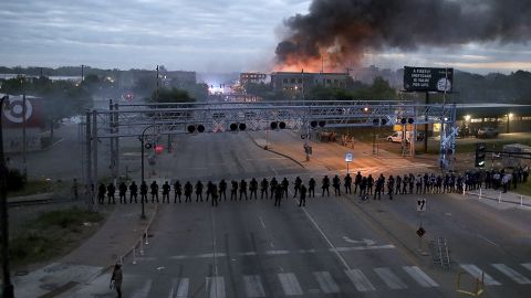 Law enforcement officers amassed along Lake Street near Hiawatha Avenue early Friday, May 29, in Minneapolis as fires burned after a night of unrest and protests in the death of George Floyd. Floyd died after being restrained by Minneapolis police officers on Memorial Day.