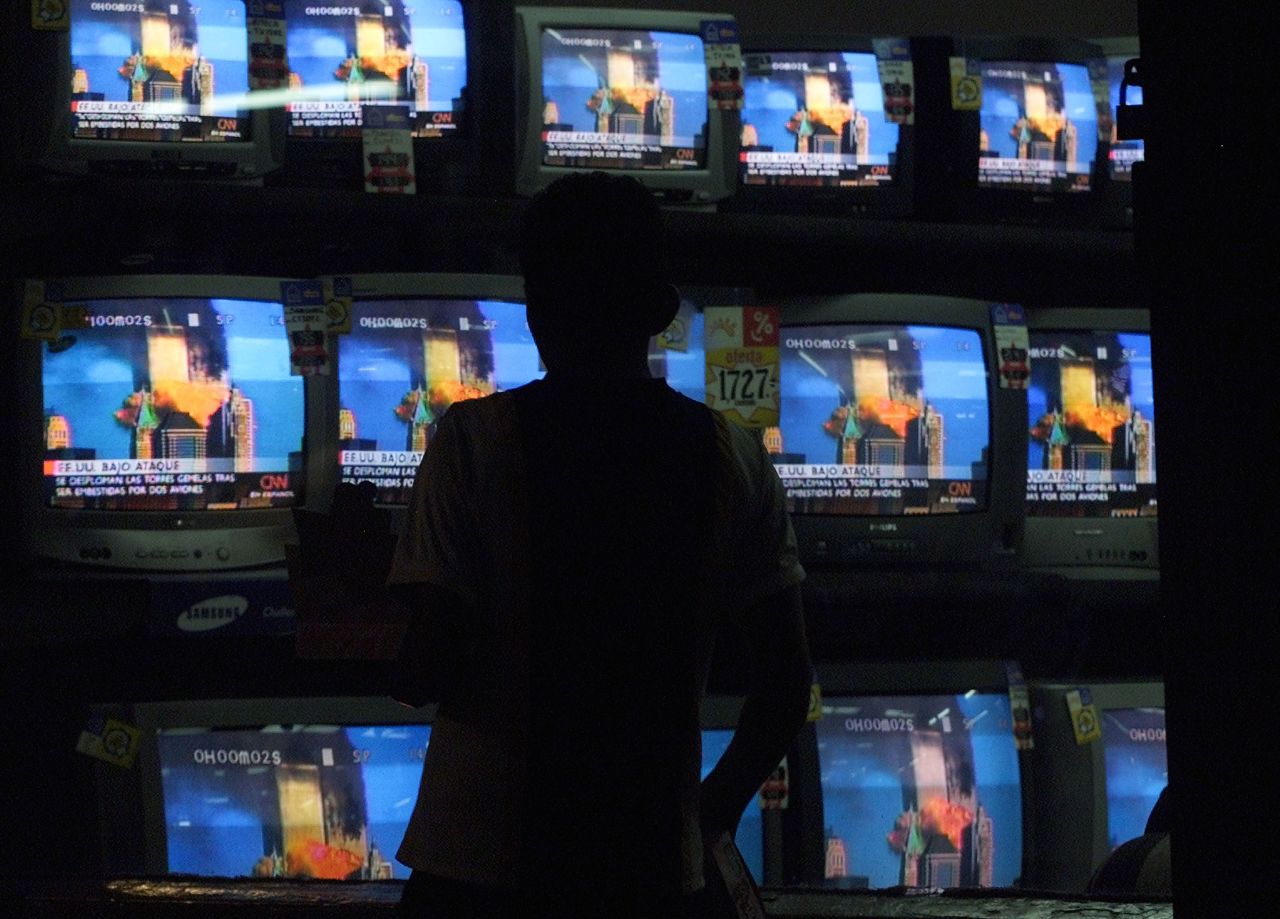 A person in Guatemala City watches the September 11, 2001, terror attacks on the World Trade Center in New York. CNN was the first cable news channel to break the news of the attacks.