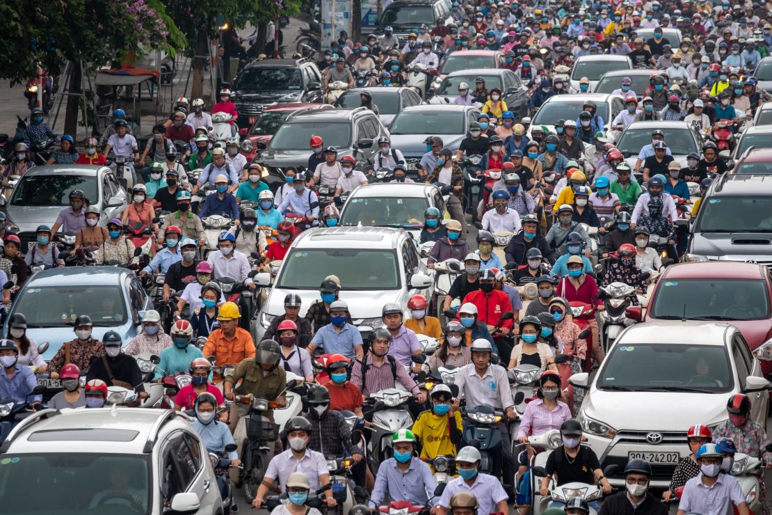 Motorbike riders with face masks are stuck in traffic during the morning peak hour on May 19 in Hanoi.