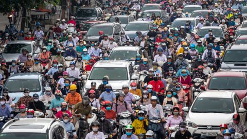 Motorbike riders with face masks are stuck in traffic during the morning peak hour on May 19 in Hanoi.