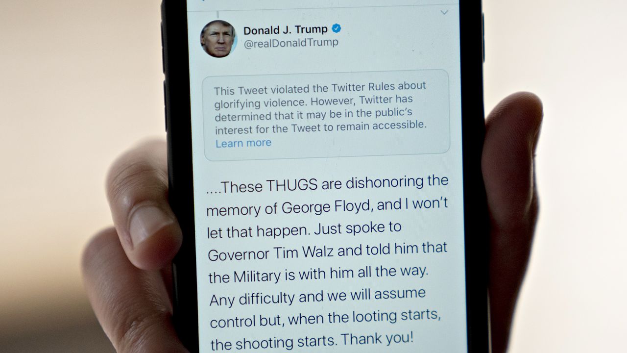 A tweet by U.S. President Donald Trump with a rule-violation notice that includes the phrase "when the looting starts, the shooting starts" is displayed on a smartphone in an arranged photograph taken in Arlington, Virginia, U.S., on Friday, May 29, 2020. Tensions between Twitter Inc. and Trump soared after the social-media platform warned users that the president broke its rules against violent speech, prompting critics to accuse the company of unfairly censoring one of its most prominent users. Photographer: Andrew Harrer/Bloomberg via Getty Images