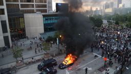 A police car burns after protesters marched to the Georgia State Capitol and returned to the area around the Centennial Olympic Park and CNN center where some confronted police Friday, May 29, 2020, in Atlanta. The protesters carried signs and chanted  messages of outrage over the death of George Floyd, a handcuffed back man who died Memorial Day in the custody of the Minneapolis police. (Alyssa Pointer/Atlanta Journal-Constitution via AP)