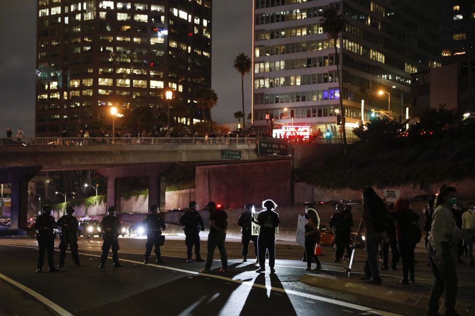 Protesters confront police officers while blocking the 110 Freeway in Los Angeles on May 29. 