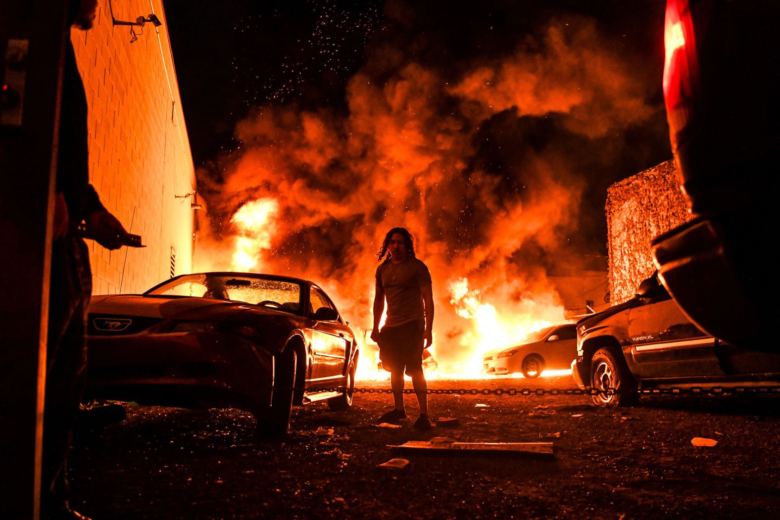 A man walks away as a car burns in a Minneapolis parking garage on May 29.