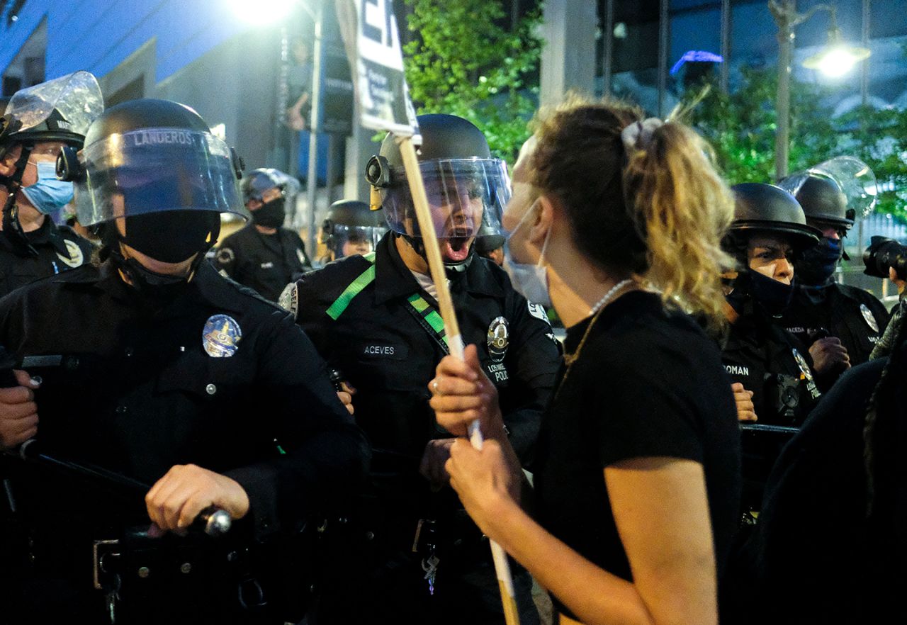 Police officers move forward to clear a street during a protest in downtown Los Angeles on May 29.