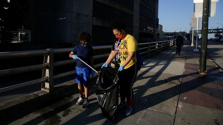 Derico Crump, 9, left, and Dayshell Crump, 30, clean the streets of downtown Atlanta in the aftermath of a demonstration against police violence on Saturday, May 30, 2020, in Atlanta. (AP Photo/Brynn Anderson)
