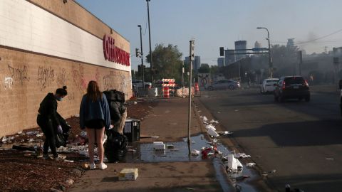 Community members clean up Saturday after another night of protests in Minneapolis. 