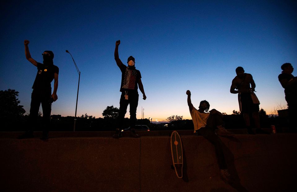 Men raise their fists after making their way onto Interstate 75 and stopping traffic in Cincinnati on May 29.