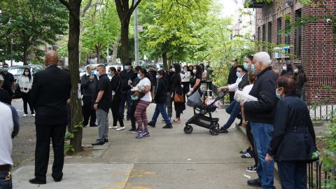 Outside the Coronel's family home, neighbors and friends gathered to bid farewell, wearing masks and trying to stay socially distant.