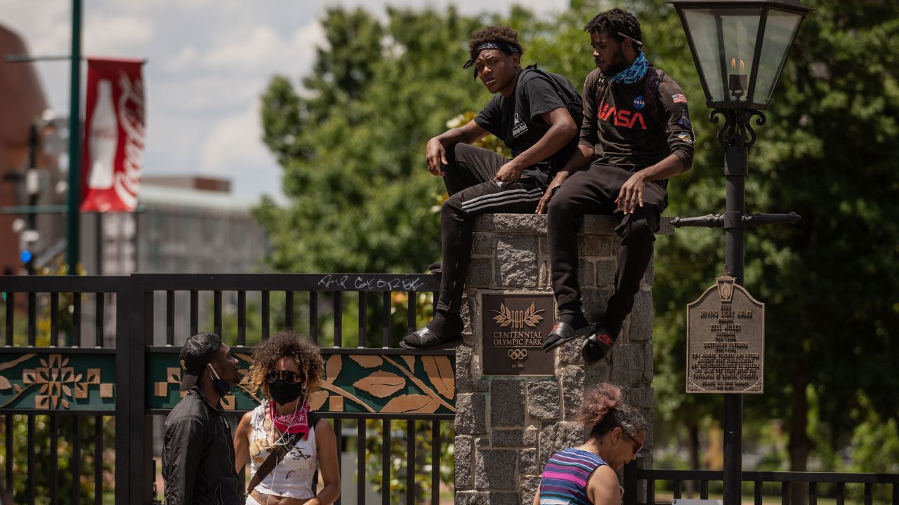 Protesters sit on a pillar at the entrance of Centennial Olympic Park in downtown Atlanta on May 30.