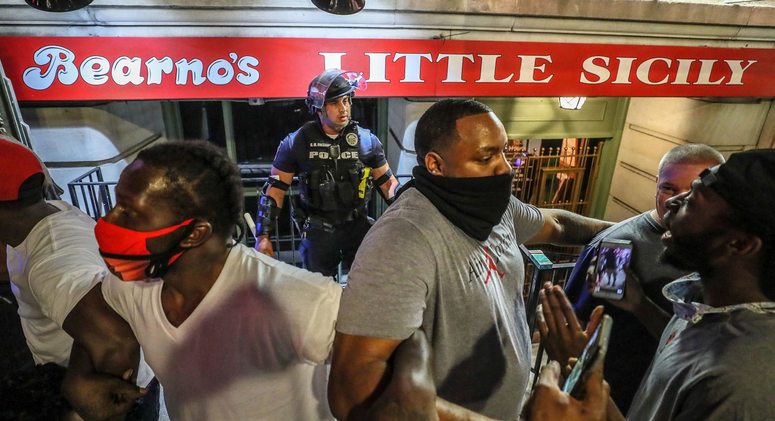 Protesters link arms and surround a police officer to protect him from the crowd in Louisville on May 28.